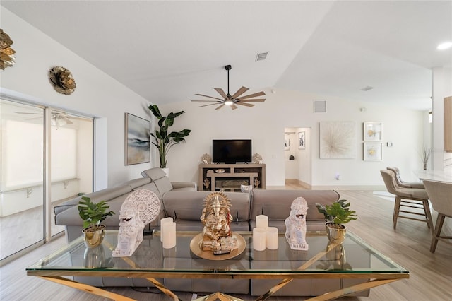 living room featuring light hardwood / wood-style floors, lofted ceiling, a fireplace, and ceiling fan