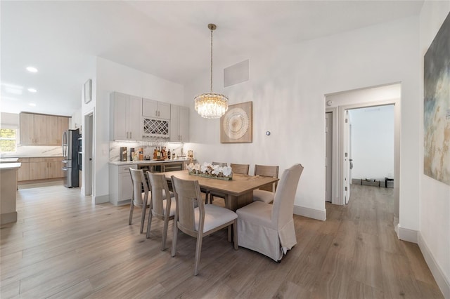 dining room with a chandelier and light hardwood / wood-style floors