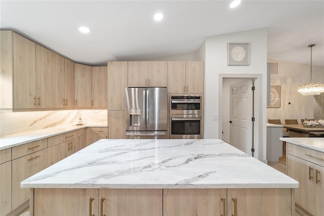 kitchen featuring light brown cabinets, stainless steel appliances, and vaulted ceiling