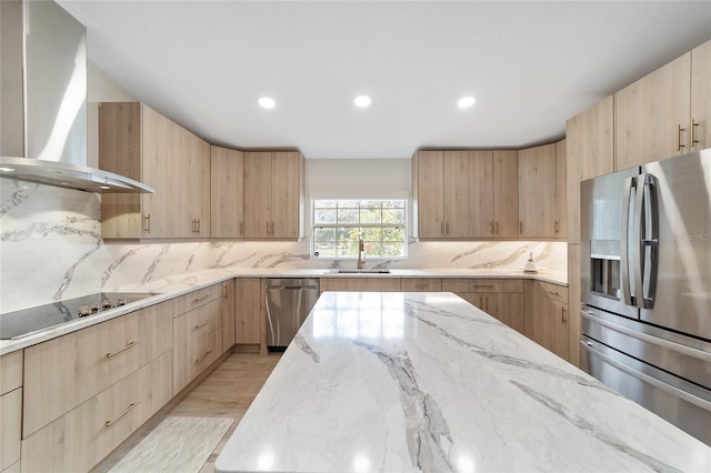 kitchen with wall chimney range hood, light hardwood / wood-style flooring, stainless steel appliances, and light brown cabinetry