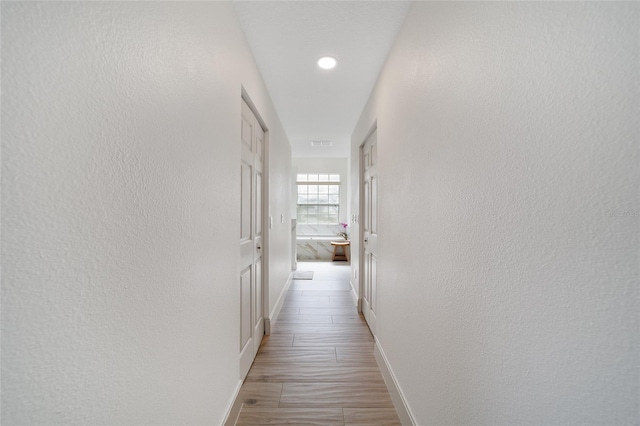 hallway with light hardwood / wood-style floors