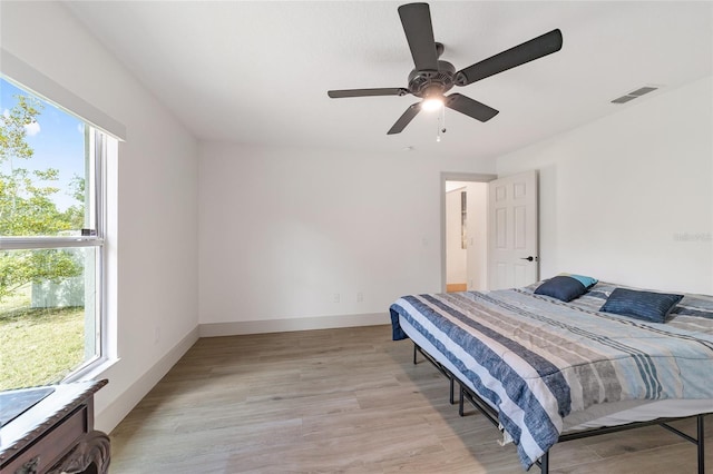 bedroom featuring light hardwood / wood-style flooring, multiple windows, and ceiling fan