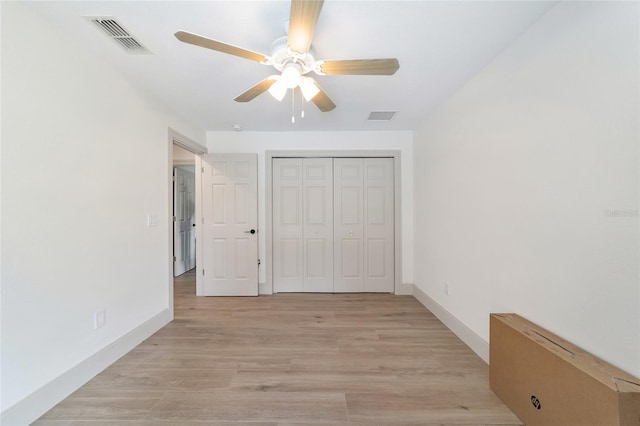 unfurnished bedroom featuring light hardwood / wood-style floors, a closet, and ceiling fan