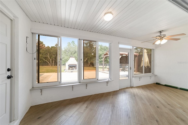 unfurnished sunroom featuring ceiling fan