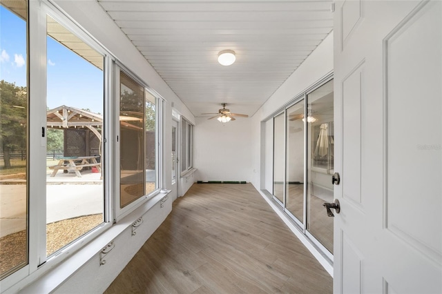 unfurnished sunroom featuring ceiling fan