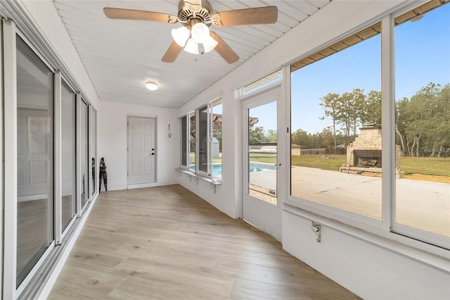 unfurnished sunroom with wood ceiling and ceiling fan