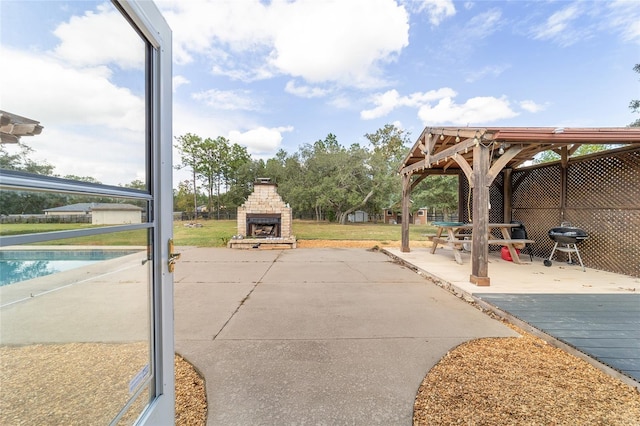 view of patio / terrace with a gazebo and an outdoor stone fireplace