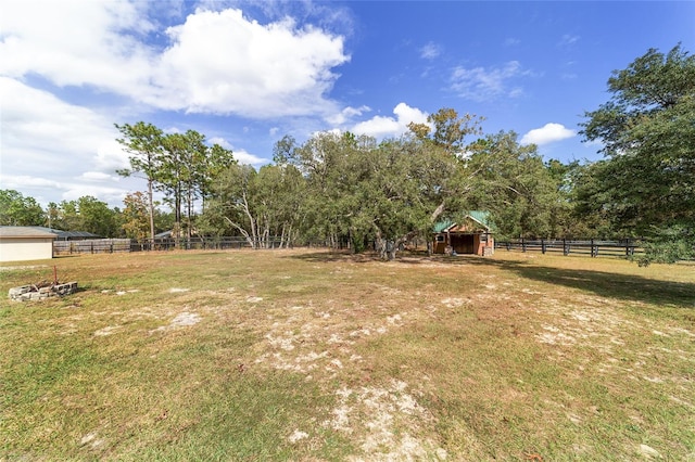 view of yard with a rural view and an outdoor structure