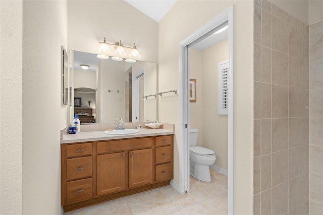 bathroom with toilet, vanity, and tile patterned floors