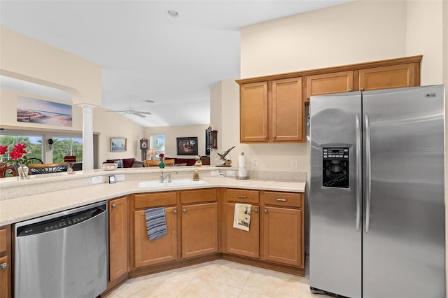 kitchen with sink, decorative columns, ceiling fan, stainless steel appliances, and lofted ceiling