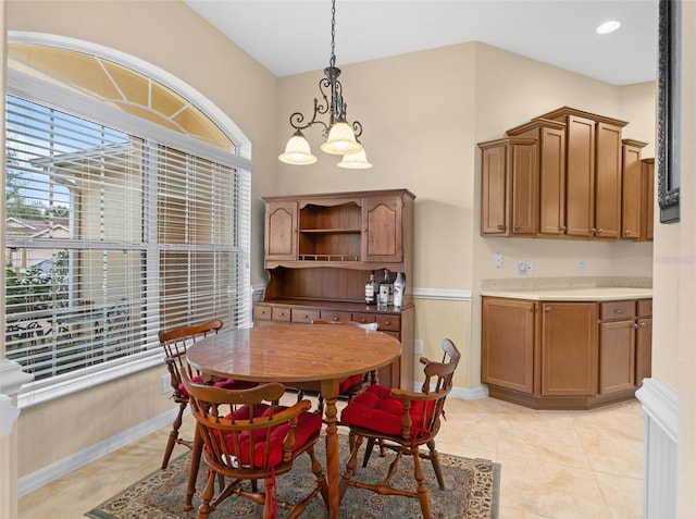 tiled dining room featuring a notable chandelier