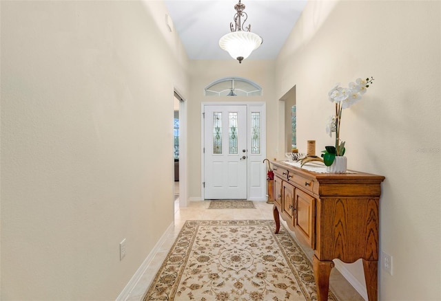 foyer featuring light tile patterned floors and baseboards