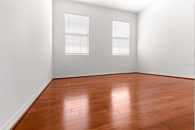 spare room with hardwood / wood-style floors and plenty of natural light