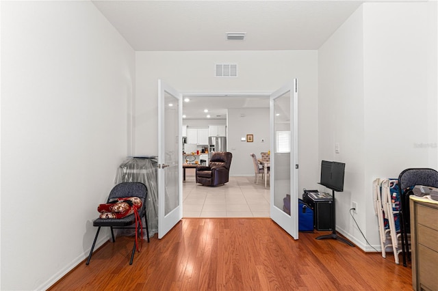 hall featuring light hardwood / wood-style floors and french doors