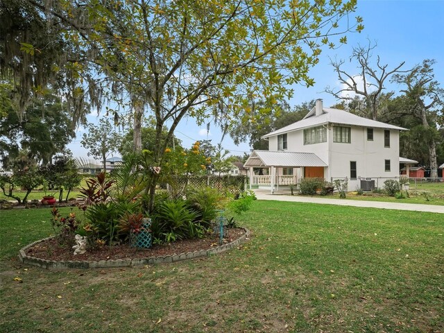 712 SW 10th Ave, Ocala, FL 34471 - view of front of house with a porch, central AC, a chimney, and metal roof