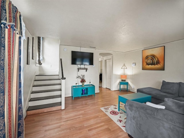 712 SW 10th Ave, Ocala, FL 34471 - living area with arched walkways, wood finished floors, baseboards, and stairway