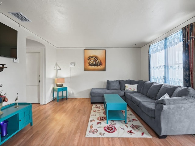 712 SW 10th Ave, Ocala, FL 34471 - living area featuring wood finished floors, arched walkways, and baseboards