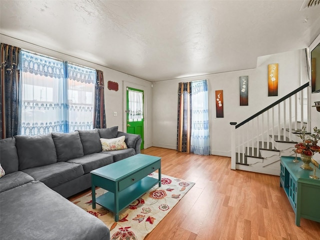 living room with a textured ceiling and light hardwood / wood-style flooring