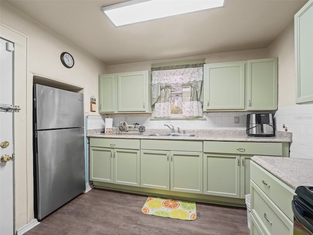 kitchen with sink, green cabinetry, dark hardwood / wood-style flooring, black / electric stove, and stainless steel refrigerator