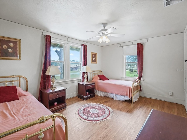 712 SW 10th Ave, Ocala, FL 34471 - bedroom featuring wood finished floors, a ceiling fan, baseboards, and a textured ceiling