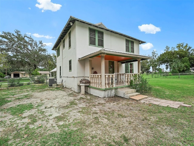 rear view of house with a yard and cooling unit