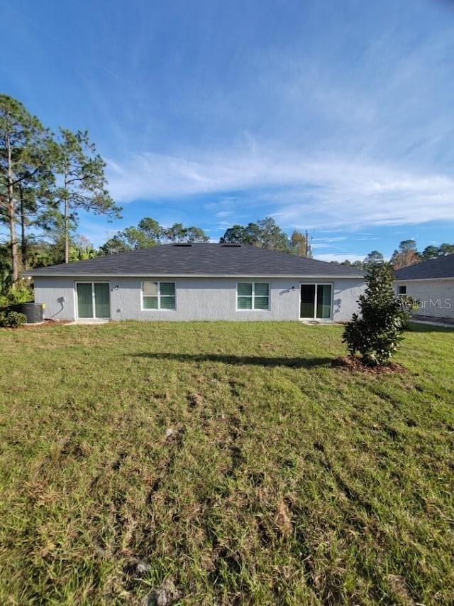 rear view of property featuring a lawn