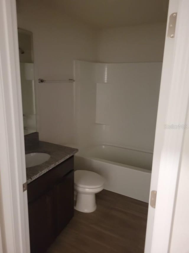 full bathroom featuring vanity, toilet, wood-type flooring, and washtub / shower combination