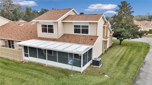 back of property featuring cooling unit, a lawn, and a sunroom