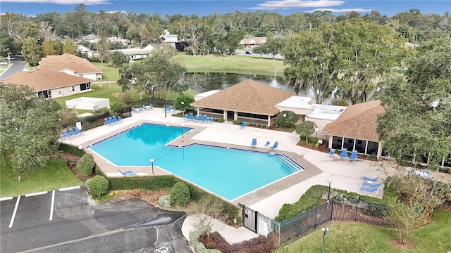 view of swimming pool featuring a water view and a patio area