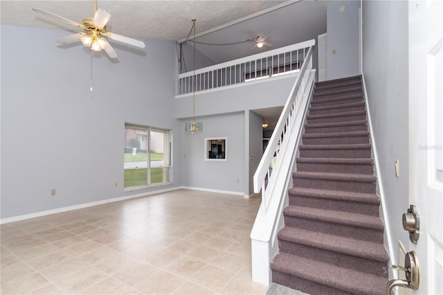 stairs featuring tile patterned floors, a high ceiling, a textured ceiling, and ceiling fan