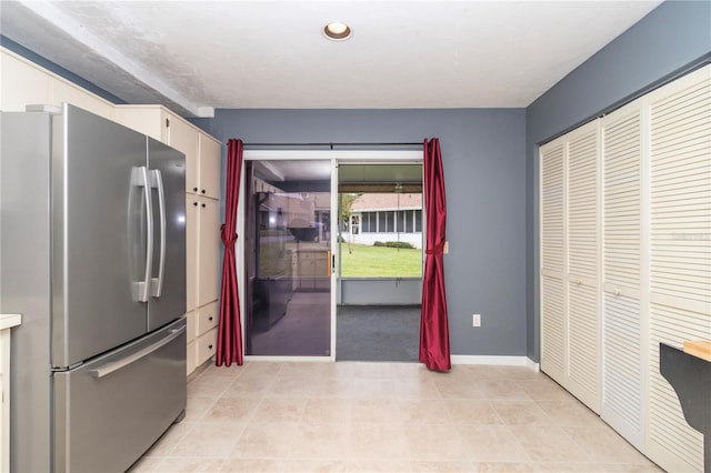 kitchen with white cabinetry and stainless steel fridge