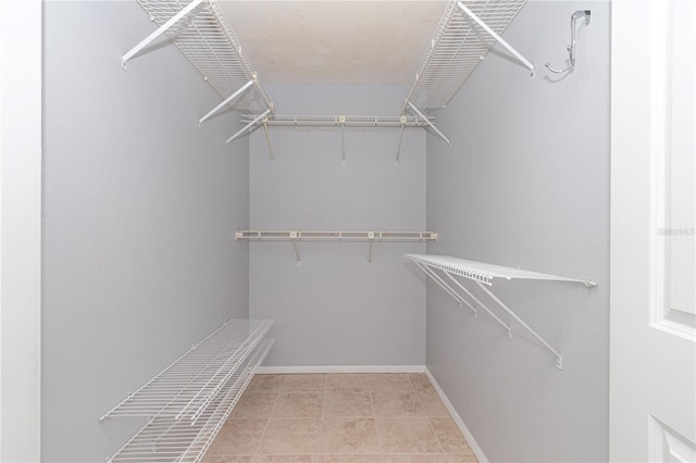 spacious closet with light tile patterned floors