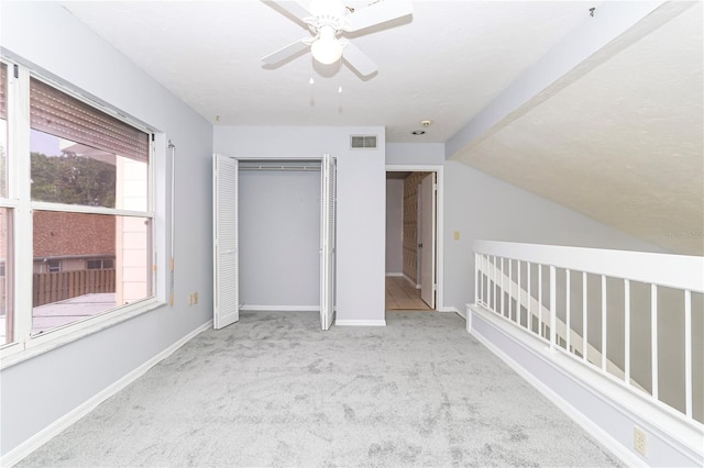 unfurnished bedroom with light carpet, a closet, and ceiling fan