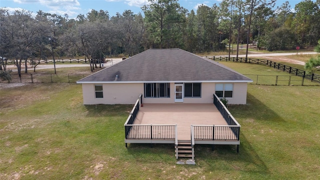 back of property with a wooden deck and a yard