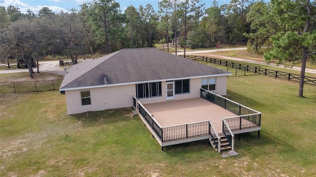 rear view of house with a deck and a lawn