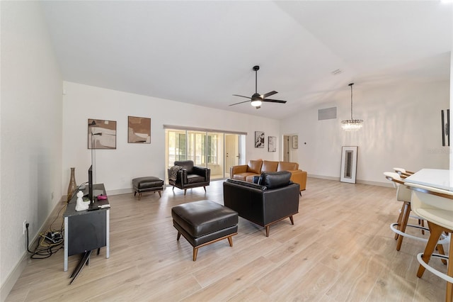 living room with lofted ceiling, ceiling fan with notable chandelier, and light wood-type flooring