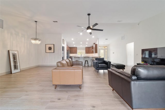 living room with a towering ceiling and ceiling fan with notable chandelier