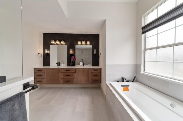 bathroom featuring vanity and tiled tub