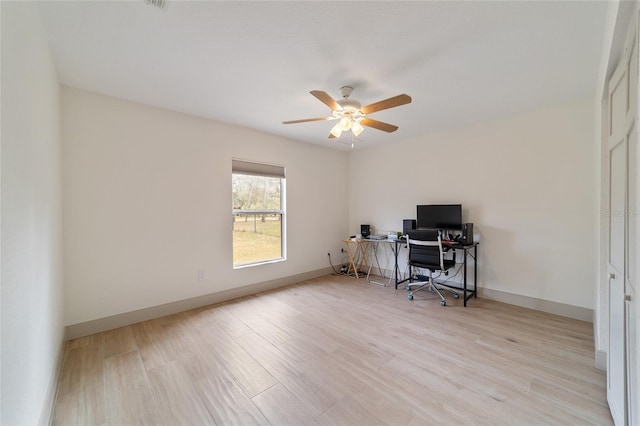 home office with light hardwood / wood-style flooring and ceiling fan