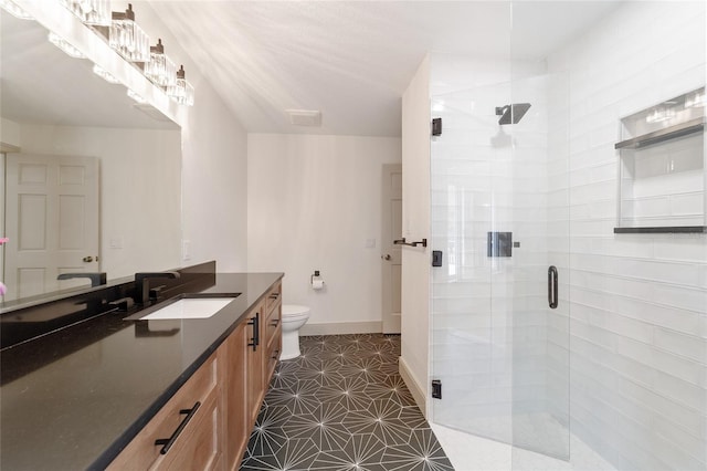 bathroom featuring a shower with door, vanity, toilet, and tile patterned floors