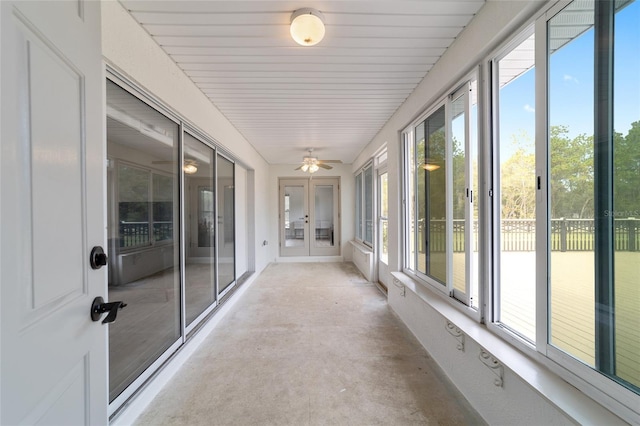 unfurnished sunroom with french doors, ceiling fan, and a healthy amount of sunlight