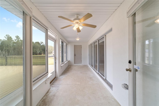 unfurnished sunroom featuring ceiling fan