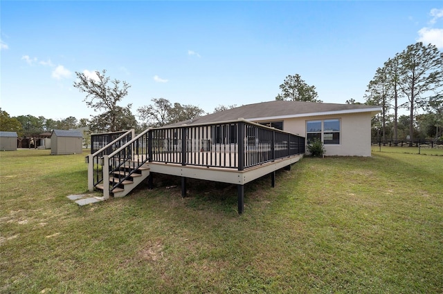 back of house featuring a wooden deck, a storage unit, and a yard