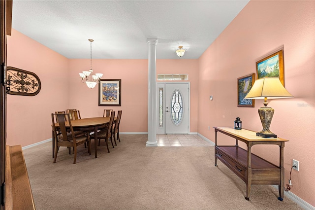 entryway featuring decorative columns, a textured ceiling, a chandelier, and light colored carpet