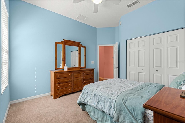 carpeted bedroom with multiple windows, a textured ceiling, a closet, and ceiling fan