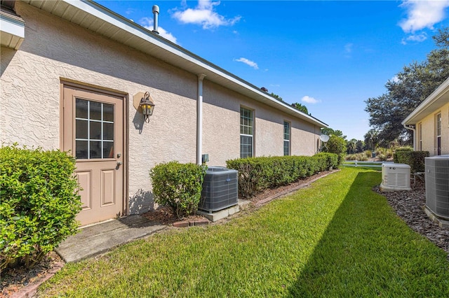 view of property exterior with a yard and central AC unit