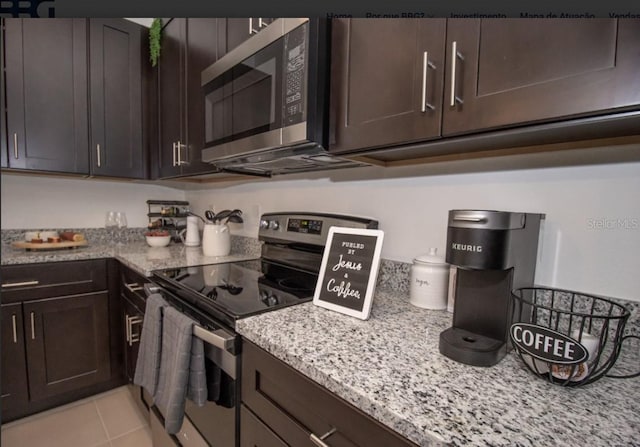 kitchen with dark brown cabinetry, appliances with stainless steel finishes, light stone counters, and light tile patterned flooring