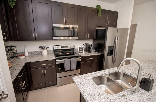 kitchen with stainless steel appliances, dark brown cabinetry, and sink