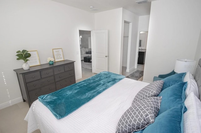 bedroom featuring ensuite bath and light tile patterned floors