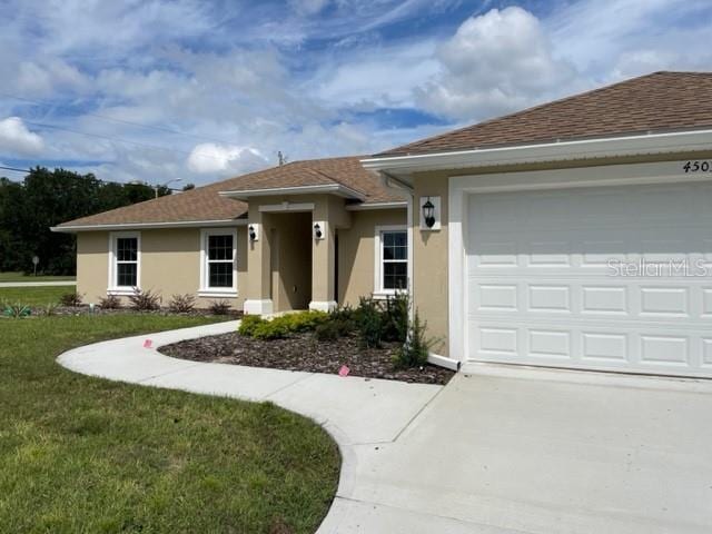 view of front of home with a garage and a front lawn